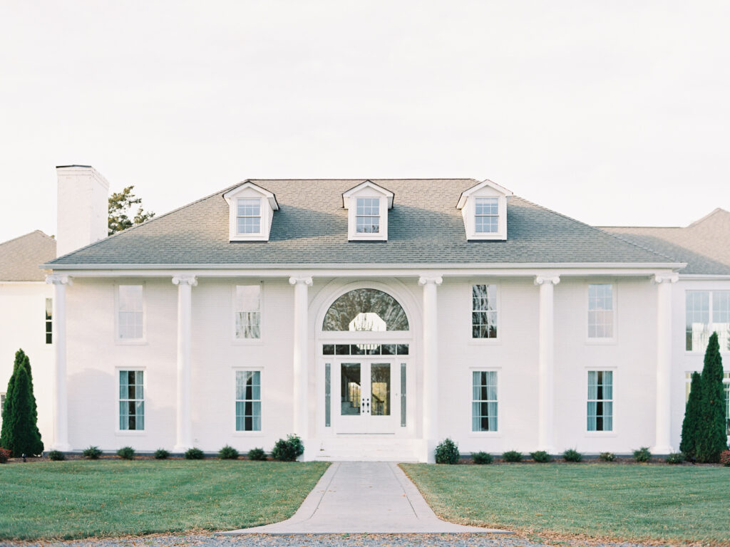 White brick Georgian-style facade of Northfield Estate in Charlottesville, Virginia, with symmetrical columns and manicured lawn.